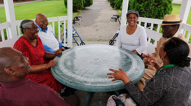 Members of Four Seasons Adult Day Care socializing around a table.