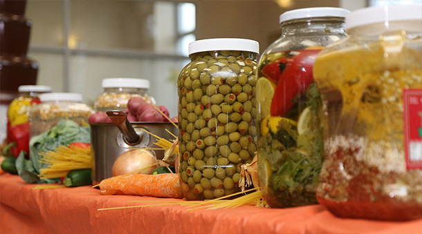 Jarred vegetables and vegetables on a table.