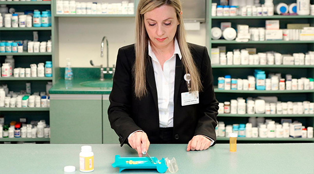 Four Seasons pharmacist counting out pills.