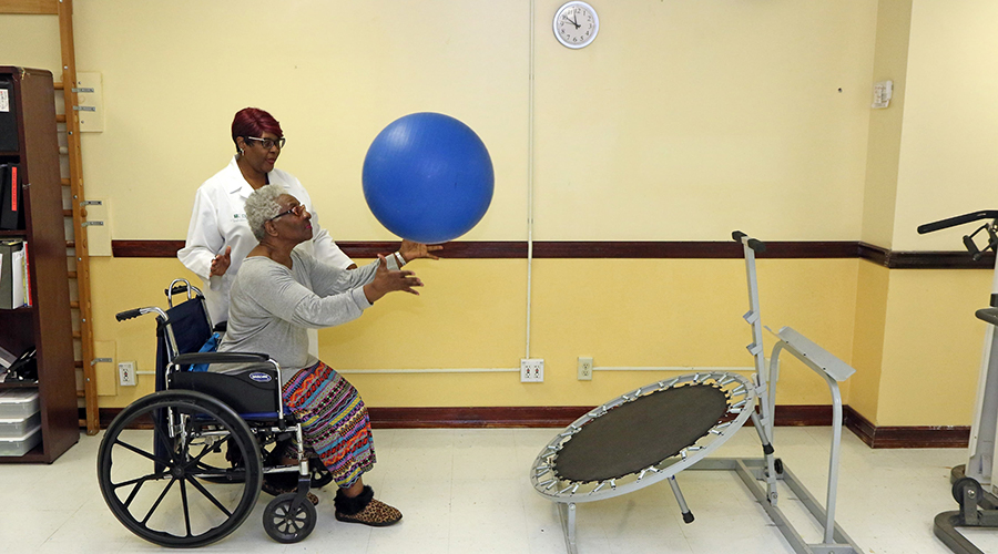 Older woman working with an occupational therapist at Four Seasons Adult Day Care in Brooklyn.