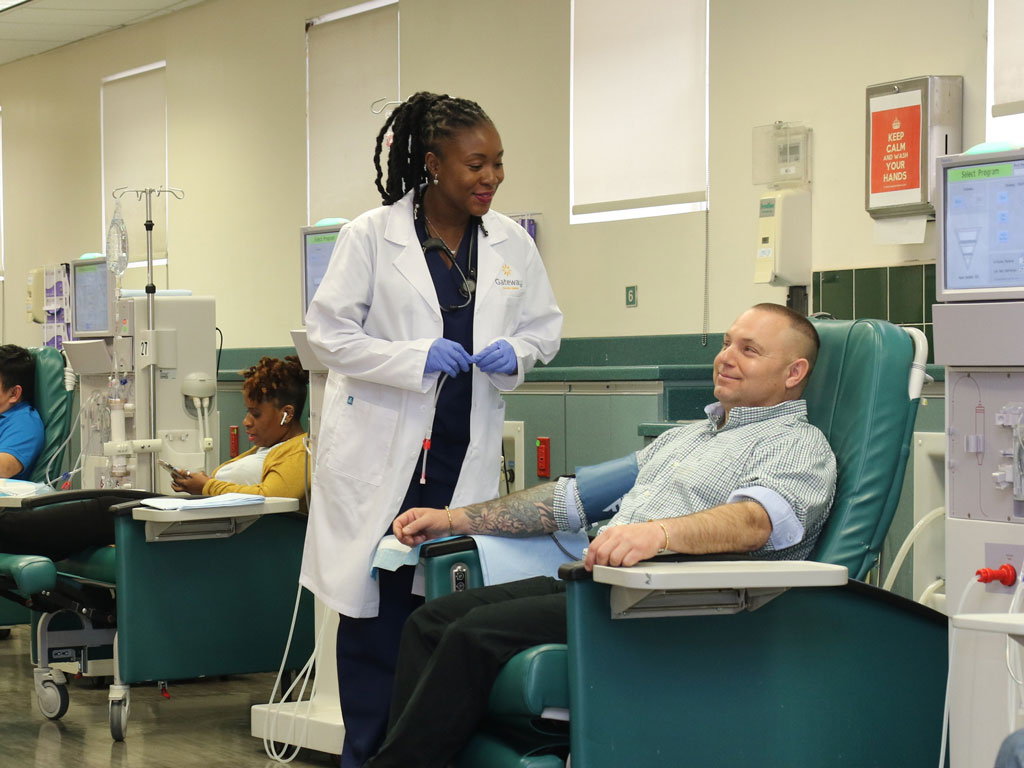 Dialysis technician at the Four Seasons Brooklyn dialysis center talks to a dialysis patient