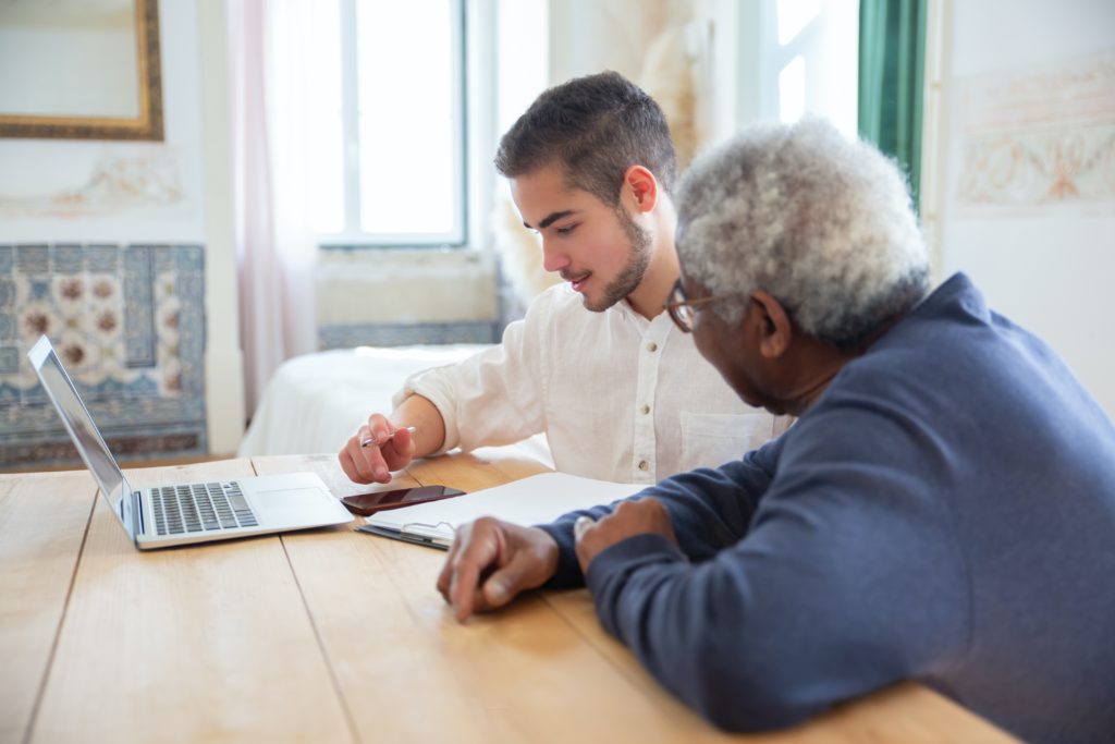 Home caregiver helping an older adult with Medicaid paperwork.