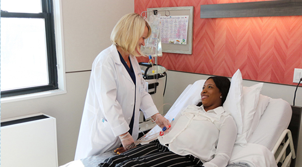 Woman laying in bed being treated by a doctor.