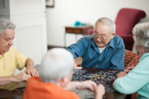 Older adults enjoying putting together a puzzle at their local adult day care center.