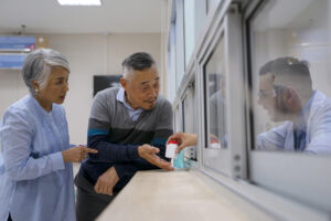 Two older adults learning about medication management at a pharmacy