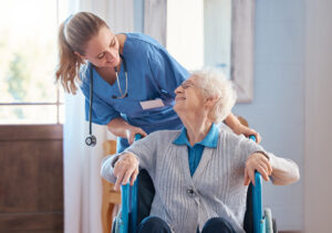 A nurse assists an elderly woman patient in a wheelchair