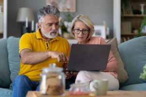 Two older adults looking at a computer.