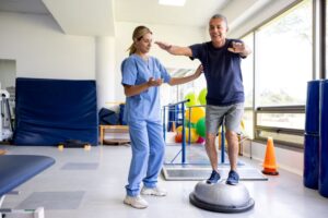 Older man works with a physical therapist to improve his balance