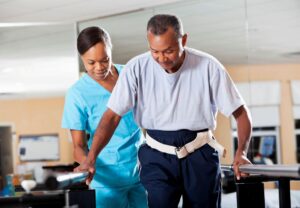 Older man participates in physical therapy after experiencing a stroke.