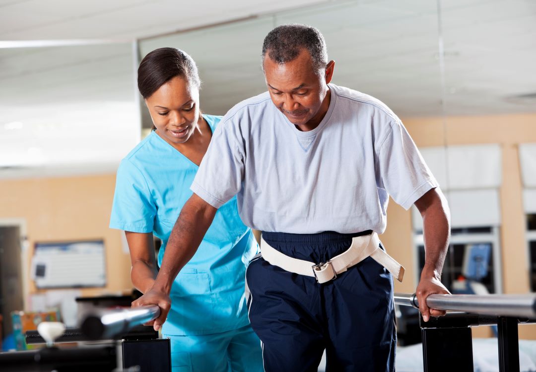 Older man participates in physical therapy after experiencing a stroke.
