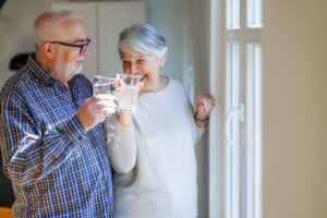 An older man and woman enjoy a glass of water