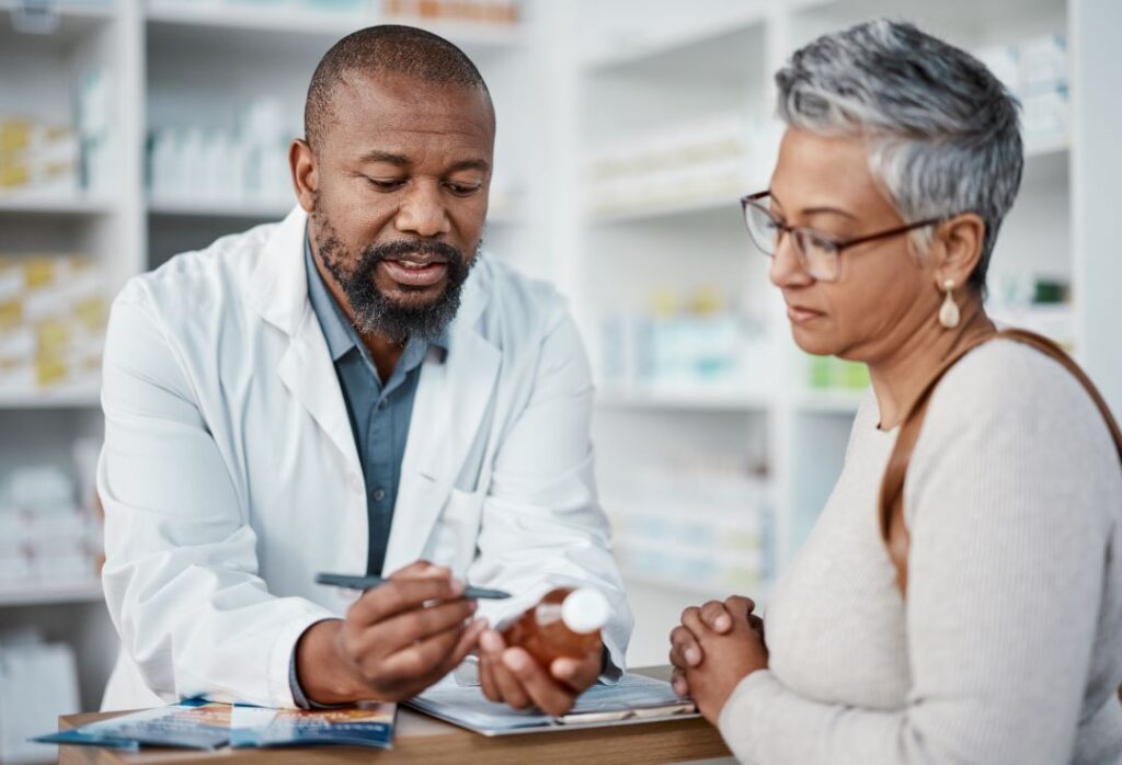 Pharmacist talks to an older woman about medication safety in the summer.