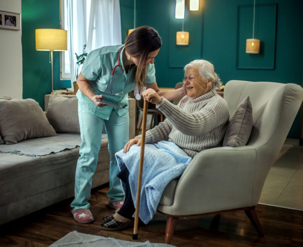 A home health care professional assists an older woman in her home.