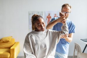 Woman participating in physical rehabilitation with a physical therapist.