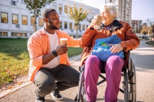 A caregiver talks with an older woman in a wheelchair.