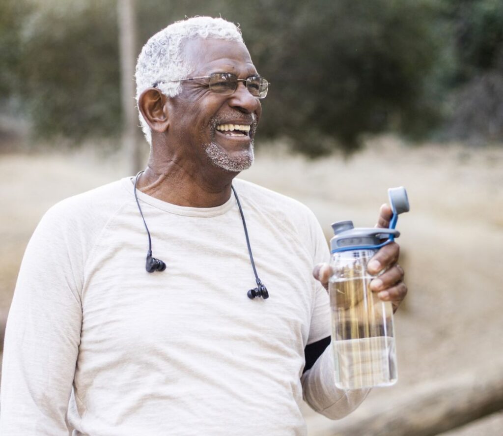 An older man takes a rest as he enjoys outdoor exercise.