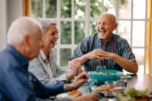 An older group of adults gather to enjoy a healthy meal.