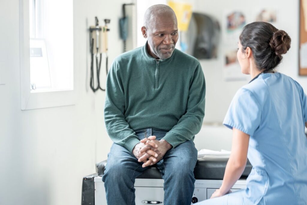 An older man talks to his doctor about his care plan.