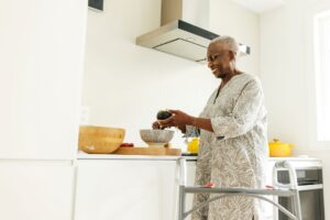 An older woman prepares food in her accessible kitchen.