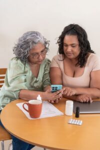 A woman helps her mother with her medications.